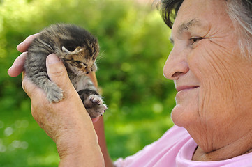 Image showing Senior woman holding little kitten