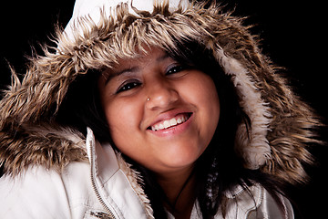 Image showing Portrait of a young latin woman with a furry hood , in autumn/winter clothes