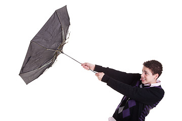 Image showing Young boy with an umbrella turned by the wind