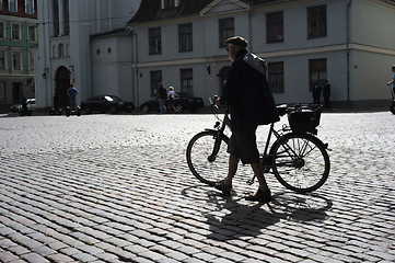 Image showing Man walking his bicycle