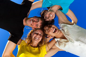 Image showing The four friends, embracing, has formed a circle and bent over a