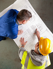 Image showing Builders examine blueprints