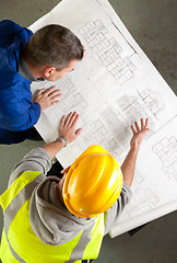 Image showing Builders examine blueprints