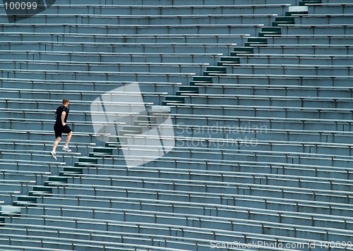 Image of man running bleachers