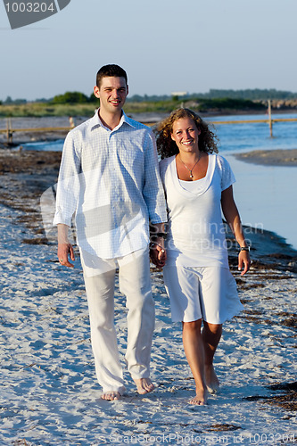 Image of Young couple walking on beach