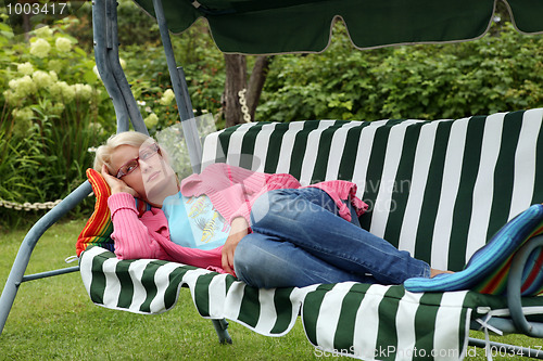 Image of young woman resting in a garden chair. (shaker)