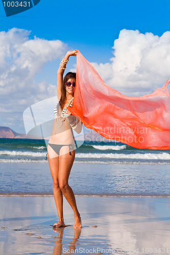Image of young blond woman dancing with kerchief against the blue sky 