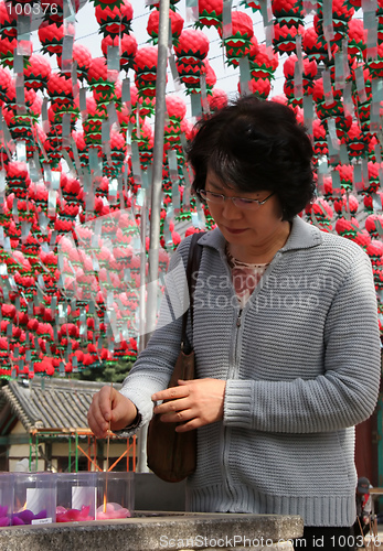 Image of Woman lighting incense