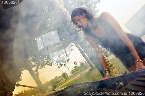 Image of Woman looking at blown engine