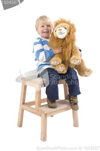 Image of Boy with toy lion on a stool