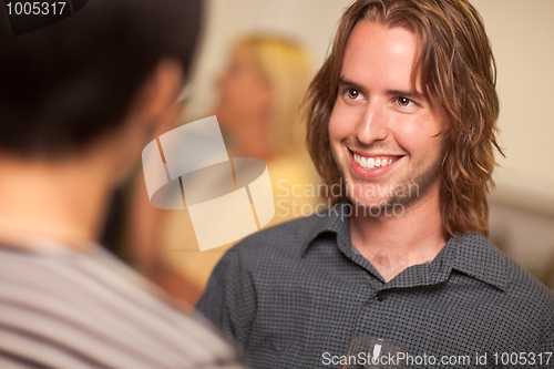 Image of Smiling Young Man with Glass of Wine Socializing