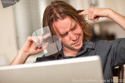 Image of Young Man Getting Loopy While Using Laptop Computer