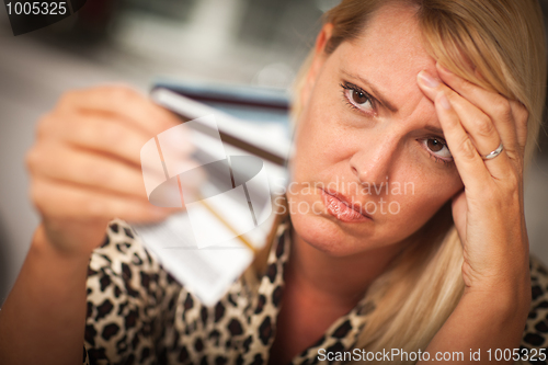 Image of Upset Woman Glaring At Her Many Credit Cards