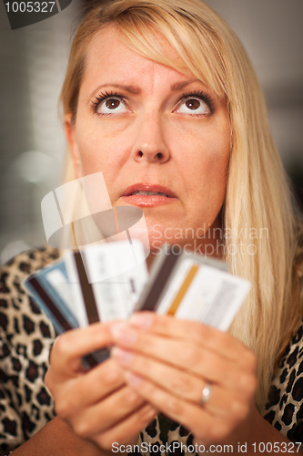 Image of Upset Woman Glaring At Her Many Credit Cards