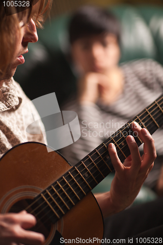 Image of Young Musician Plays His Acoustic Guitar as Friend Listens