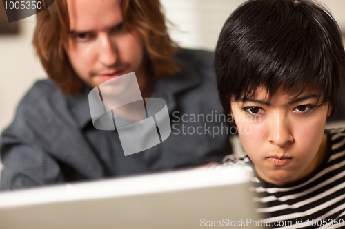 Image of Young Man and Diligent Woman Using Laptop Together