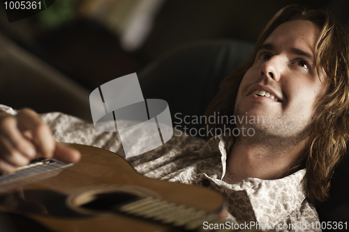 Image of Young Musician Plays His Acoustic Guitar