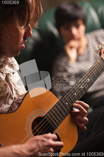 Image of Young Musician Plays His Acoustic Guitar as Friend Listens