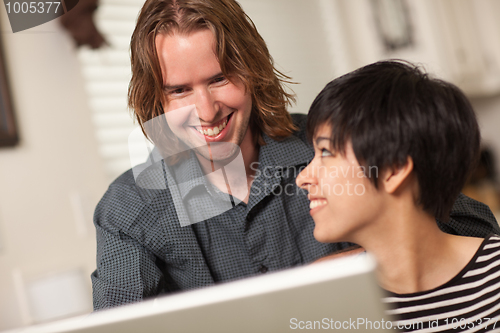 Image of Happy Young Man and Woman Using Laptop Together