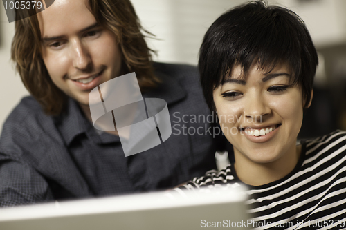 Image of Happy Young Man and Woman Using Laptop Together