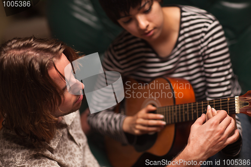 Image of Young Musician Teaches Female Student To Play the Guitar