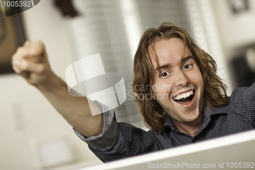 Image of Happy Young Man Using Laptop Computer