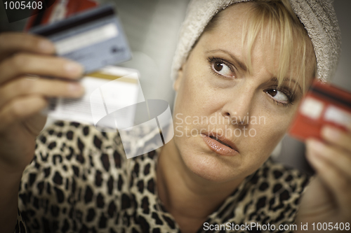 Image of Upset Woman Glaring At Her Many Credit Cards.