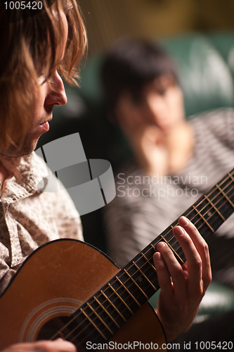 Image of Young Musician Plays His Acoustic Guitar as Friend Listens