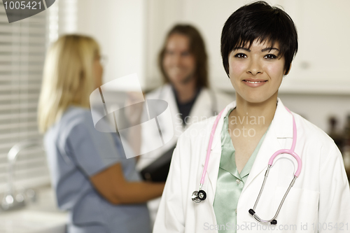 Image of Pretty Doctor Smiles at Camera as Colleagues Talk