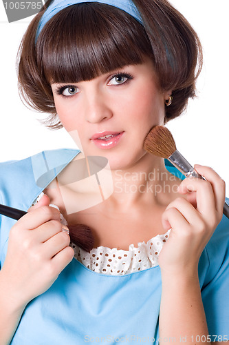 Image of woman in blue dress with two make-up brushes 