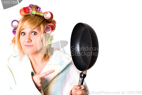 Image of funny housewife with curlers and pan