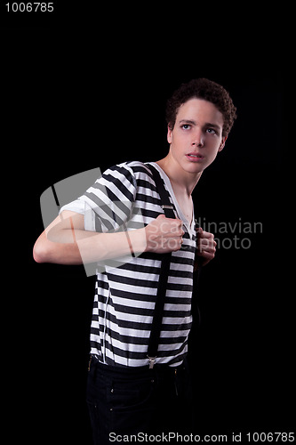 Image of Young confident man holding a trouser braces