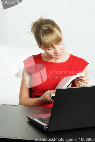 Image of Blonde woman reading magazine