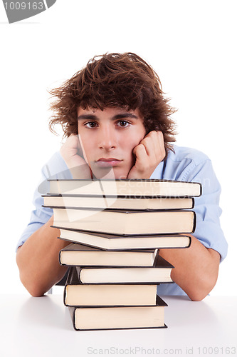 Image of cute boy bored, among books, on his desk