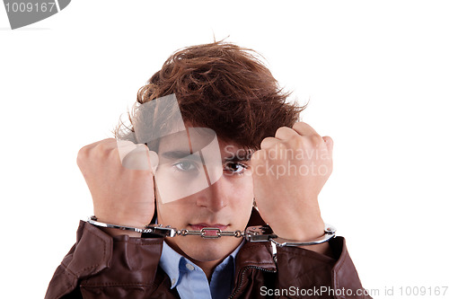 Image of Arms on the face, of a young man, with a handcuffs on the hands