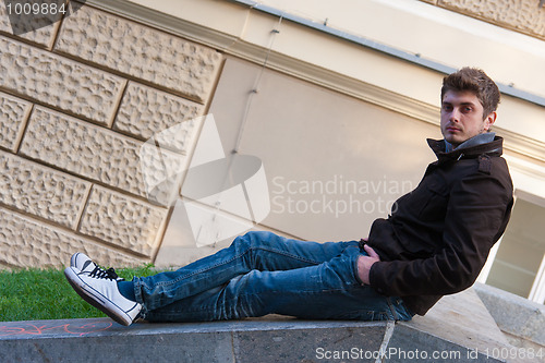 Image of Young man sitting on slope steps