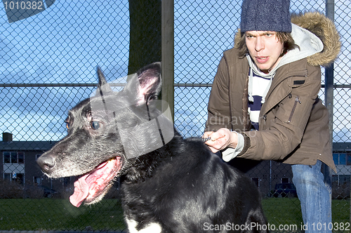 Image of Vicious dog leaping away from his owner