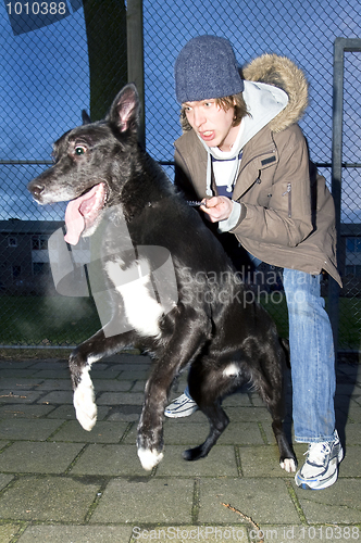 Image of Vicious dog leaping away from his owner