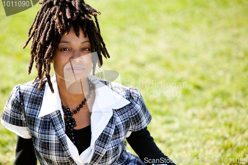 Image of Attractive Young Woman Sitting in a Park