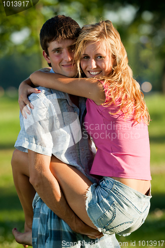 Image of A couple of lovers - a young man holding a girl on his hands in 