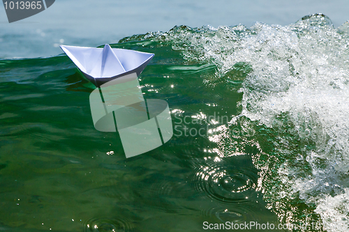 Image of Paper boat struggling with a huge foamy waves