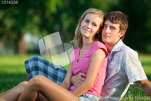 Image of Couple resting on the grass in the park