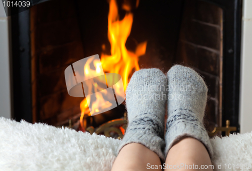 Image of Children's feet are heated in the fireplace