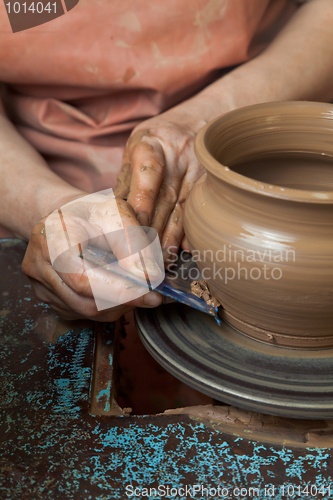 Image of Potter creates a pitcher on a pottery wheel