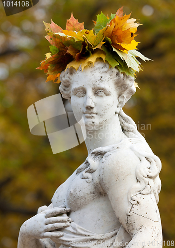 Image of A wreath of autumn yellow leaves on her head a beautiful marble 