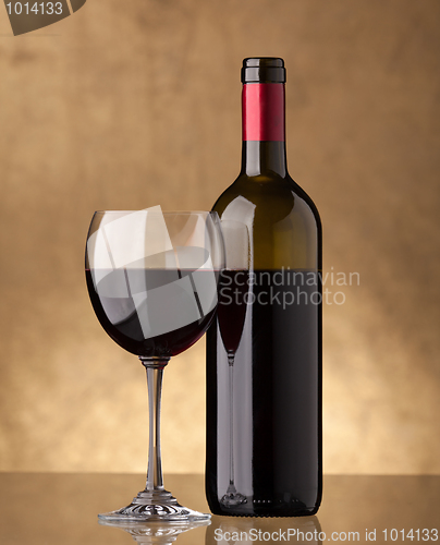 Image of A bottle of red wine and filled a wine glass