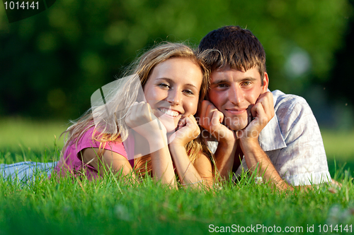 Image of Couple resting on the grass in the park