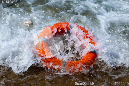 Image of Red lifebuoy in the foam of the waves