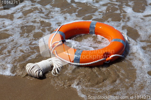 Image of Red lifebuoy in foamy waves