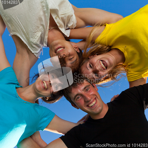 Image of Below view of joyful teens embracing and looking at camera with 